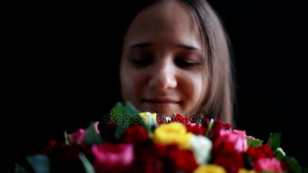 Gyönyörű nő egy nagy csokor virágnak a karjában szag egy illatos, színes rózsák fekete háttér. 1920 x 1080