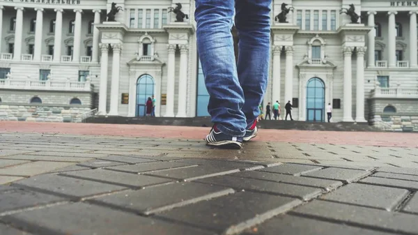 Businessmen feet walks down a city side walk