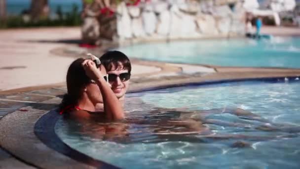 Wellness Spa pár relaxační venkovní bazén luxusní resort Spa ústup. Šťastná mladá žena a muž v sluneční brýle uvolněně opřenou o cestování dovolená dovolenou. 1920 × 1080