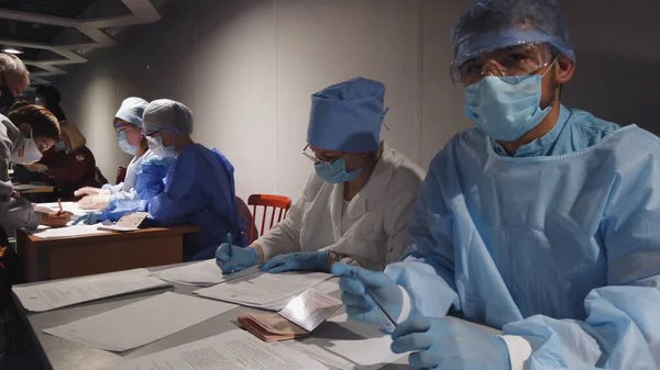 Medical workers in protective suit at checkpoints airports registers new arrivals from the flight. infection epidemic corona passengers. Novosibirsk, Russia, 14 april 2020