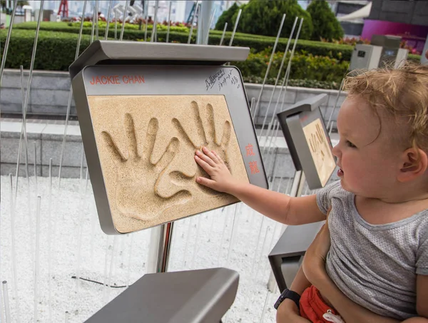 Fiú érinti Jackie Chan Handprints — Stock Fotó