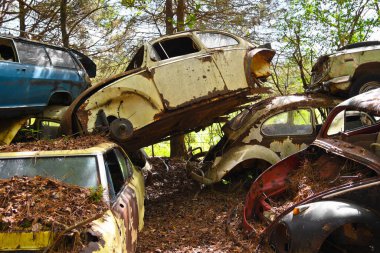 Close-up Image of Several Old Scrap Cars Stacked in a Junk Yard clipart