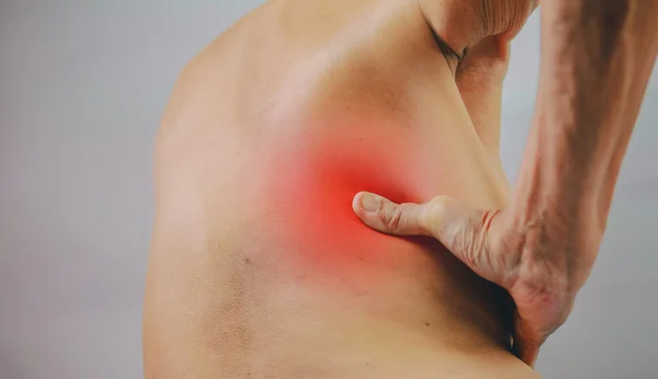 Mano de hombre mayor sosteniéndolo hacia atrás y masajeando en la zona del dolor. Concepto con Salud y Medicina — Foto de Stock