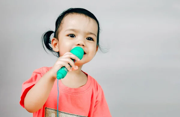 Menina segurando um microfone isolado no fundo branco — Fotografia de Stock