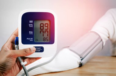 bir dijital tansiyon ile hasta tutan doktor