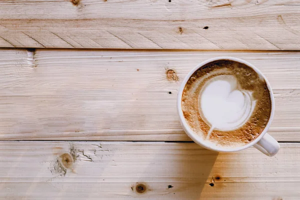 Latte art kawy na podłoże drewniane, widok z góry — Zdjęcie stockowe