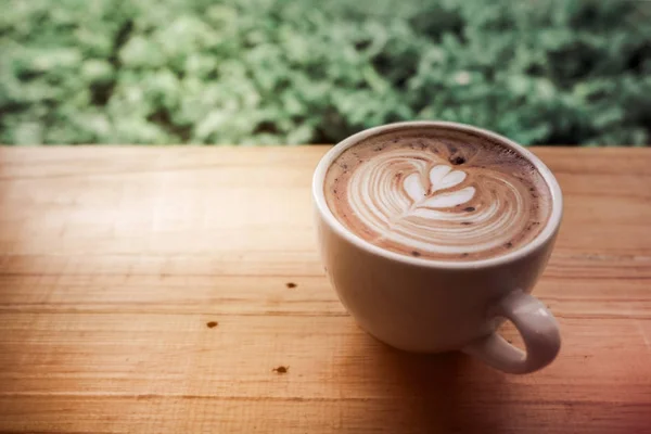 Una taza de café latte arte con corazón en una taza blanca con l verde — Foto de Stock