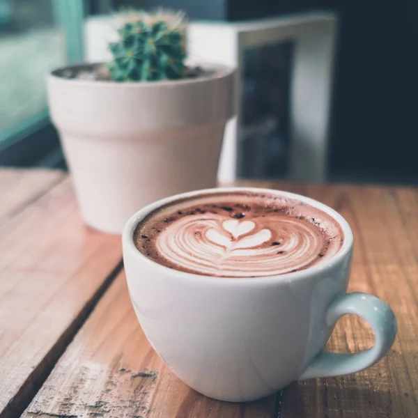 Una taza de café latte arte con corazón en una taza blanca con cactus — Foto de Stock