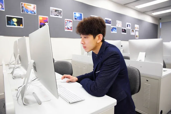Молодий чоловік використовує комп'ютер в класі — стокове фото