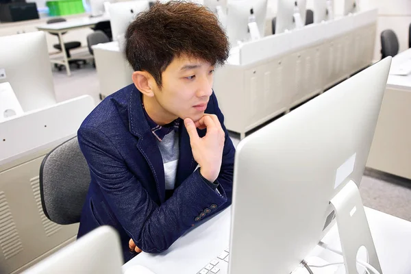 Junger Mann benutzt Computer im Klassenzimmer — Stockfoto