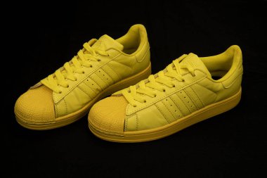 Pavia, İtalya - 3 Şubat 2020: Adidas Superstar Pharrell Williams Yellow, siyah arkaplanda stüdyo portresi