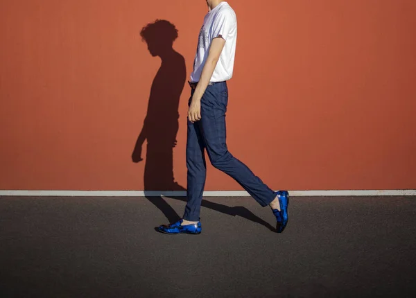 Joven Con Mocassini Caminando Por Calle Sobre Fondo Rojo Liso —  Fotos de Stock