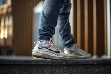Milan, Italy - December 27, 2018: Young man wearing a pair of Nike Air Max 97 Off-White shoes in the street - illustrative editorial clipart