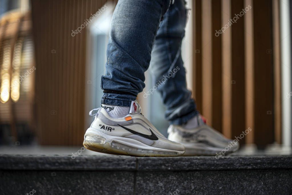 Milan, Italy - December 27, 2018: Young man wearing a pair of Nike Air Max 97 Off-White shoes in the street - illustrative editorial