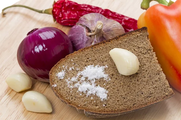 ライ麦パンや野菜に塩を振りかける — ストック写真