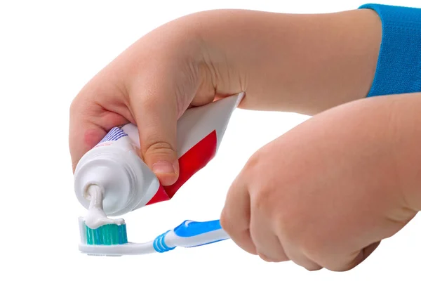 El niño aprieta la pasta dental en el cepillo de dientes — Foto de Stock