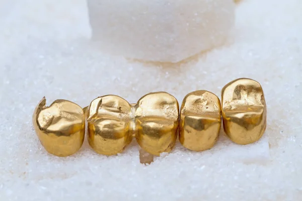 Gold dental crowns on sugar — Stock Photo, Image