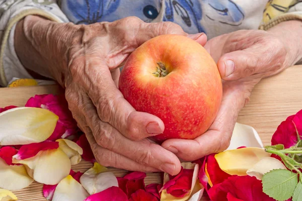 Manos de una anciana con una manzana —  Fotos de Stock