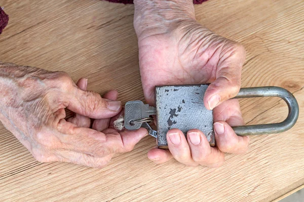 Hände einer alten Frau mit einem altmodischen Schloss — Stockfoto