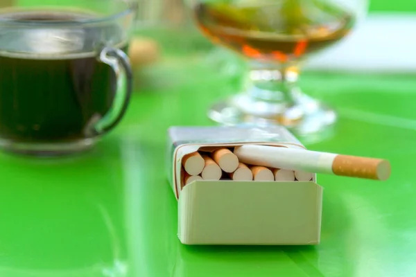 Open pack of cigarettes on a green table — Stock Photo, Image