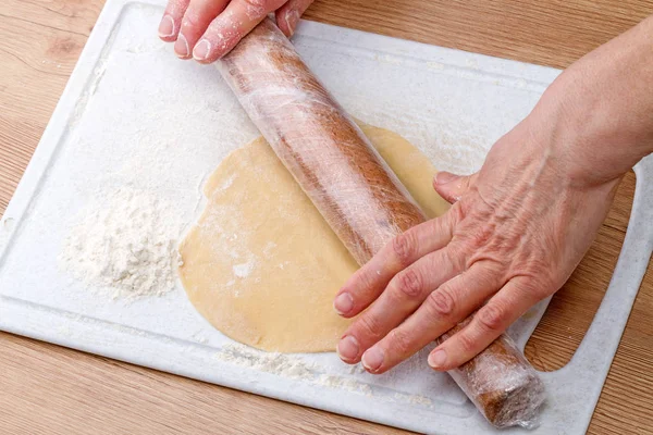 Рука со скалкой выкатывает тесто — стоковое фото