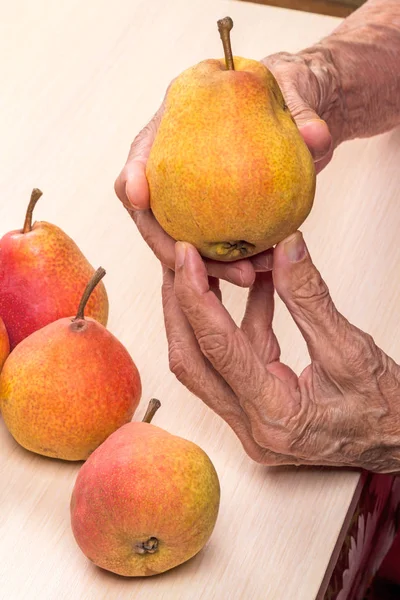 Manos de una anciana con peras —  Fotos de Stock