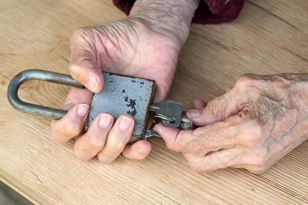 Schloss in den Händen einer alten Frau — Stockfoto