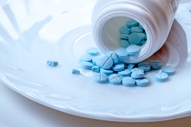 Beyaz bir plaka üzerinde mavi tabletlerden