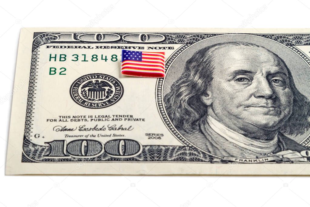 $ 100 dollar bill and tiny volumetric flag USA isolated on a white background