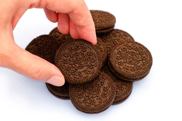 Woman hand taking Oreo cookie from heap of Oreo cookies — Stock Photo, Image