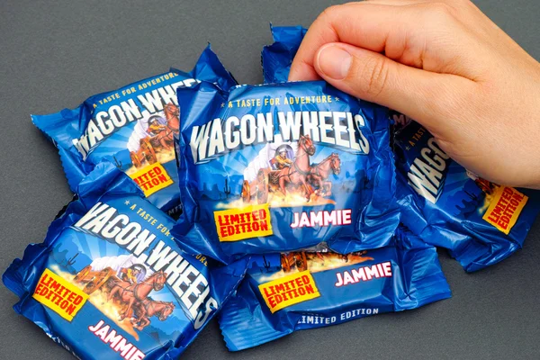 Person hand taking Jammie Wagon Wheels cookie — Stock Photo, Image