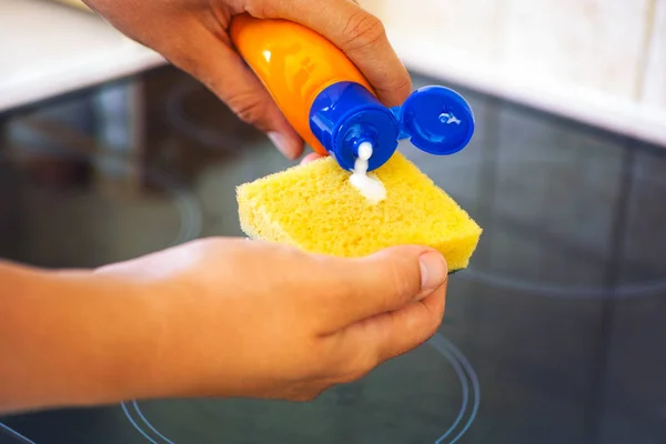 Manos de mujer con esponja amarilla y botella de detergente limpiador — Foto de Stock
