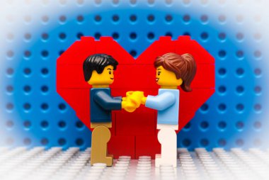 Lego çift ayakta kalp önünde