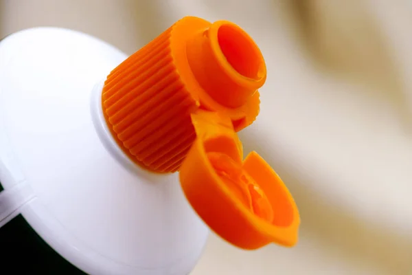 Tampa laranja aberta do tubo de pasta de dentes — Fotografia de Stock