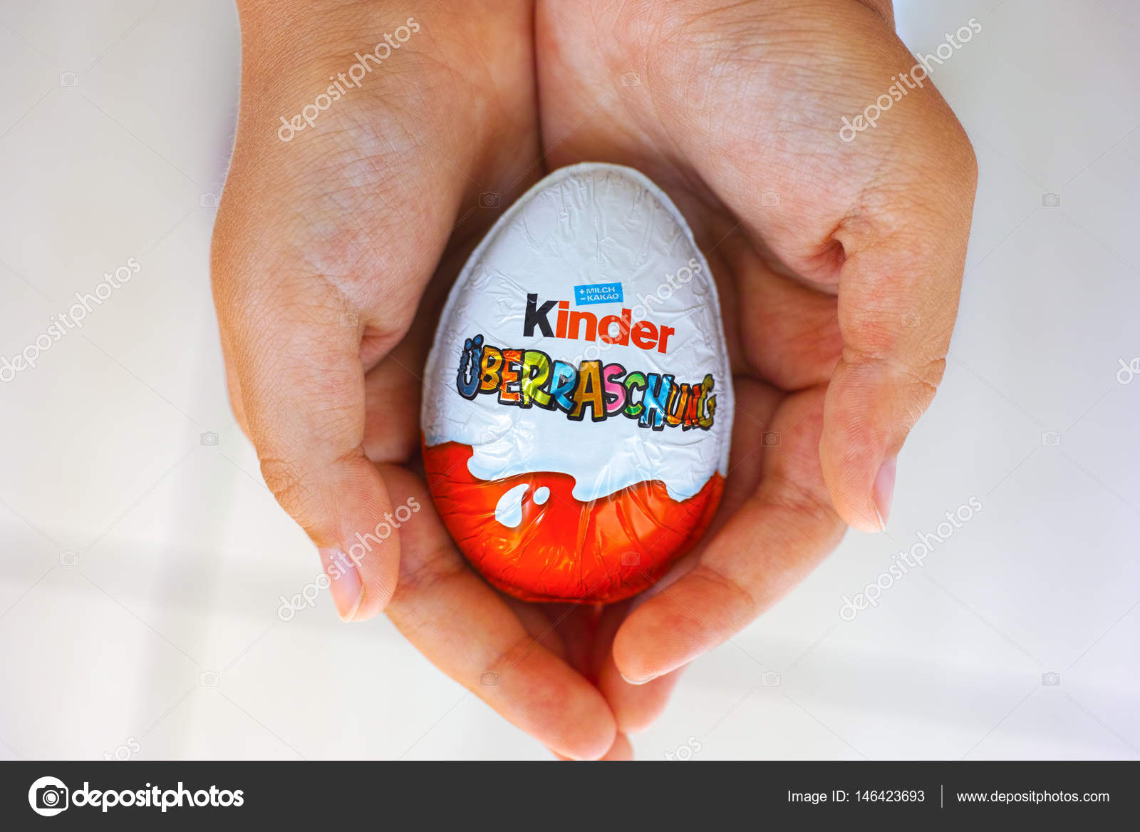 Child hands with Kinder Surprise egg Stock Editorial Photo