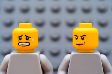 İki Lego minifigures - bir deli ve bir korkuttu. Gri arka planı. 