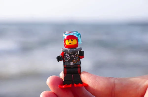 Лего ныряльщик в женских пальцах — стоковое фото