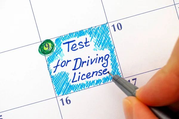 Woman fingers with pen writing reminder Test for Driving License — Stock Photo, Image