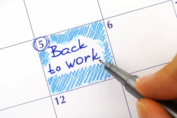 Žena ruku s modrým perem připomenutí zápisu zpět do práce v kalendáři — Stock fotografie
