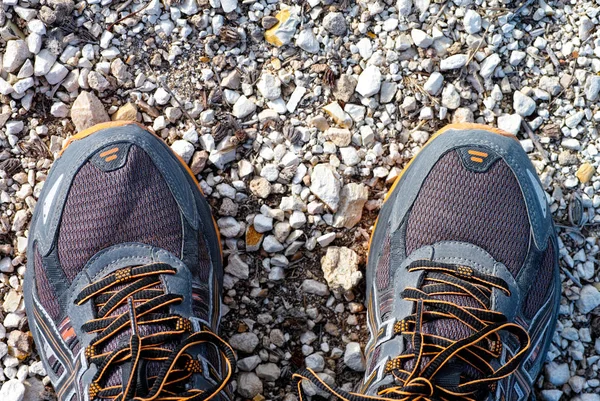 เท้าในรองเท้าวิ่งยืนบนเส้นทางหิน . — ภาพถ่ายสต็อก