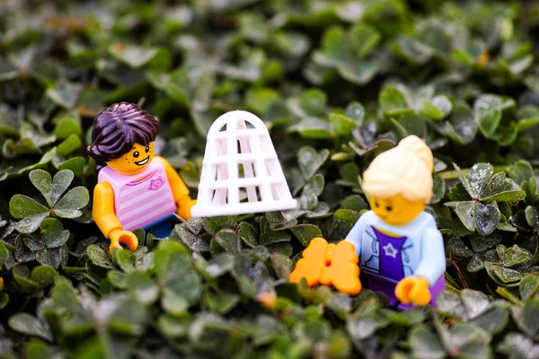 Две мини-фигурки Лего, ловящие бабочку на лугу . — стоковое фото