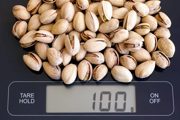 Roasted and salted pistachios on digital scale — Stock Photo, Image