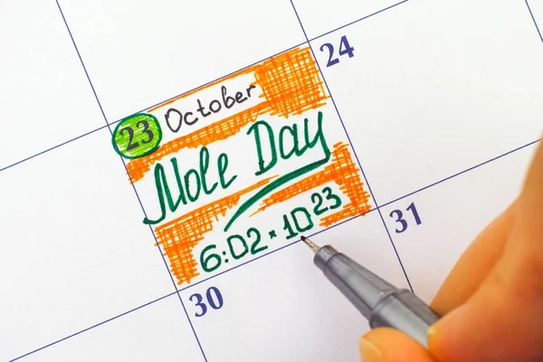 Dedos de mulher com caneta escrevendo lembrete Mole Day no calendário — Fotografia de Stock