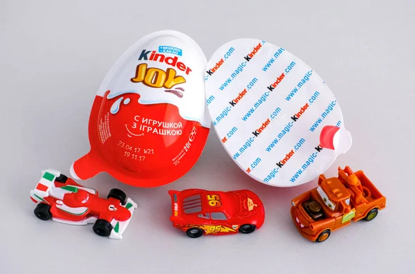 Kinder vreugde eieren met drie Kinder Cars speelgoed op grijze achtergrond — Stockfoto