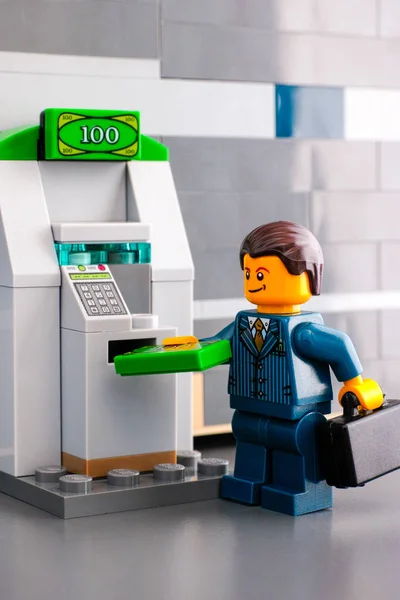 Lego empresário retirar dinheiro do ATM — Fotografia de Stock