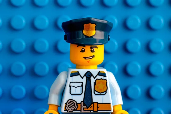 Retrato de Lego policial minifigura com placa de base azul backgr — Fotografia de Stock