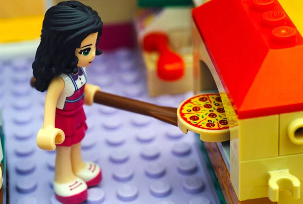 Lego-Mädchen benutzt Paddel, um Pizza in den Pizzaofen zu legen — Stockfoto