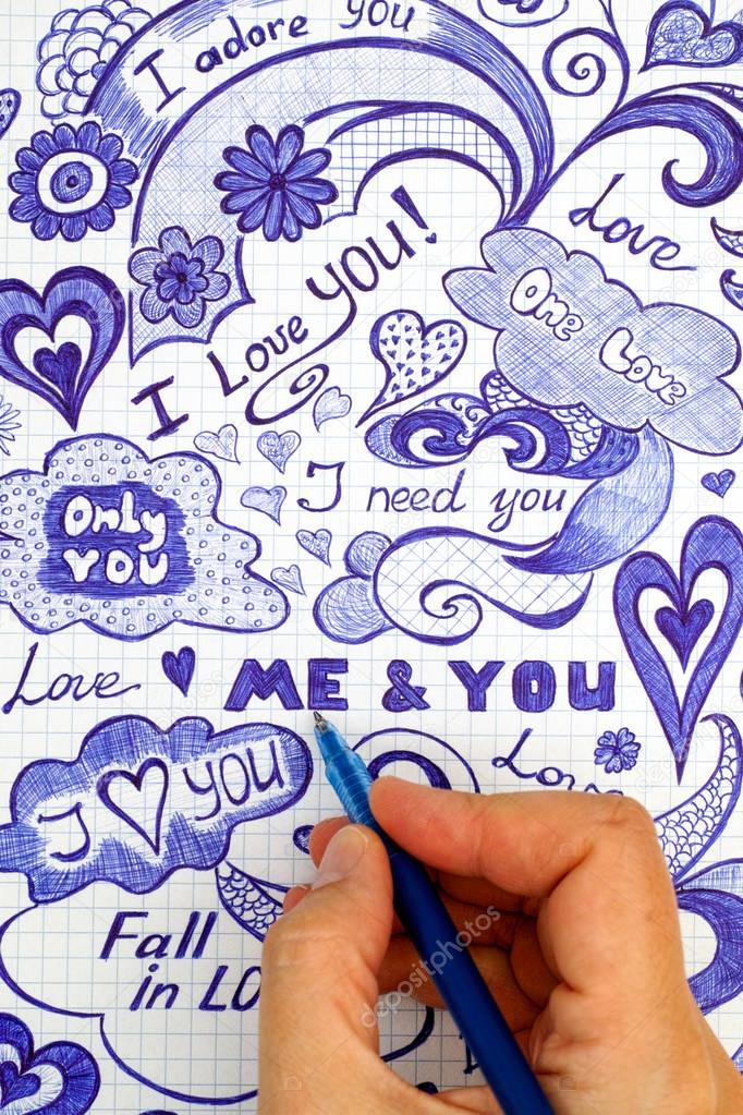 Woman hand with ballpoint pen draws love doodles messages