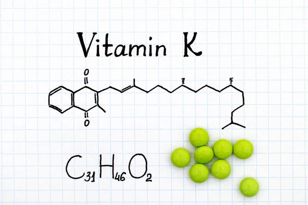 Chemische formule van vitamine K en pillen. — Stockfoto