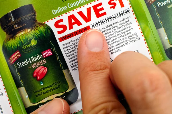 Doigts de personne sur Irwin Naturals coupon de réduction . — Photo